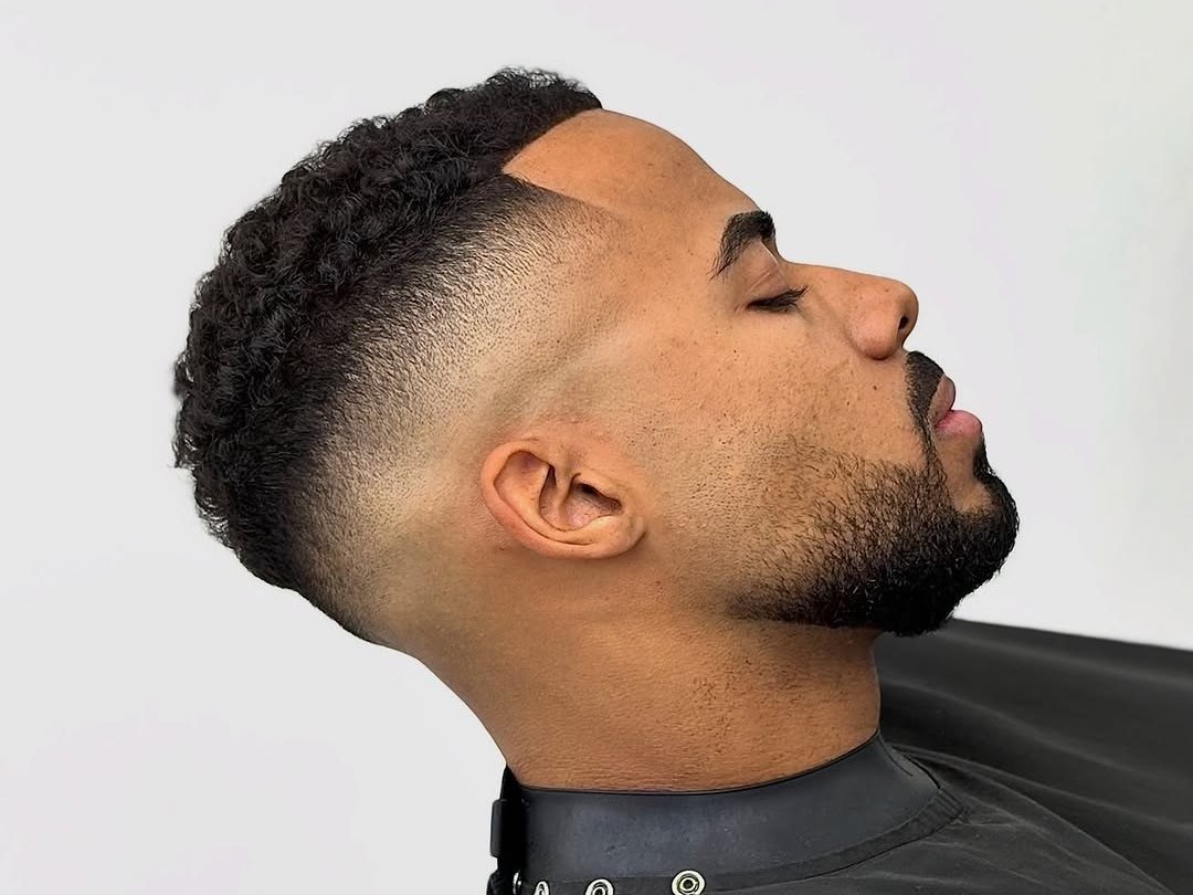 Corte de cabelo em fade alto com tesoura, fotografado na barbearia