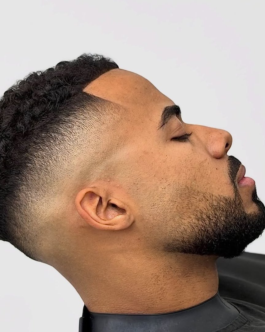 Corte de cabelo em fade e barba, fotografado na barbearia